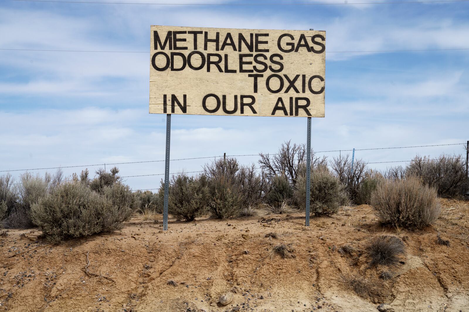 A sign protesting emissions from oil and gas stands across from Lybrook Elementary School, in Counselor, N.M., Navajo Nation, on Tuesday, March 11, 2025. (Nadav Soroker/Searchlight New Mexico via AP)
