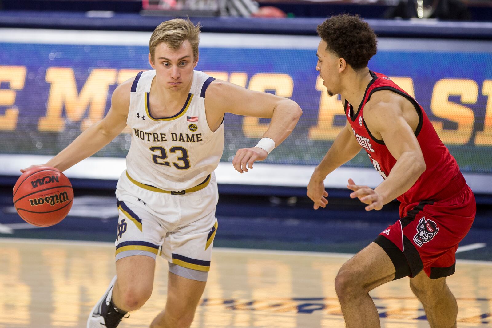 Notre Dame's Dane Goodwin (23) drives in next to North Carolina State's Jericole Hellems during the first half of an NCAA college basketball game Wednesday, March 3, 2021, in South Bend, Ind. (AP Photo/Robert Franklin)