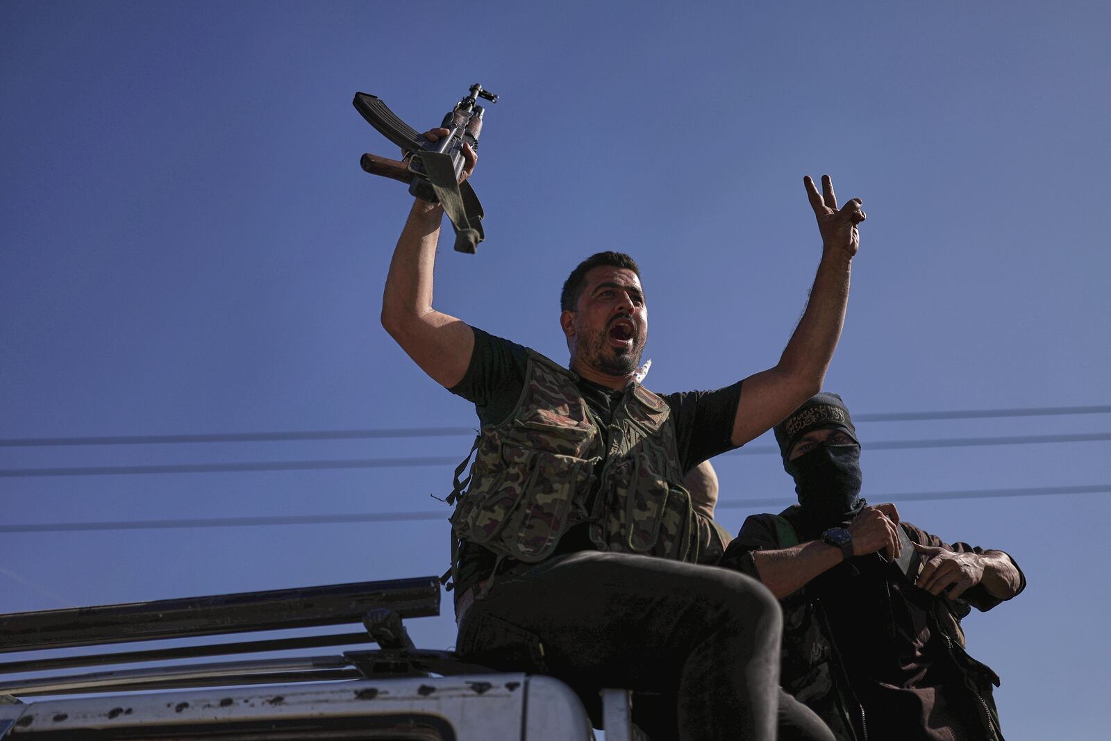 A Bedouin fighter flashes victory sign and shouts slogans at Mazraa village on the outskirts of Sweida city, during clashes between the Bedouin clans and Druze militias, southern Syria, Friday, July 18, 2025. (AP Photo/Ghaith Alsayed)