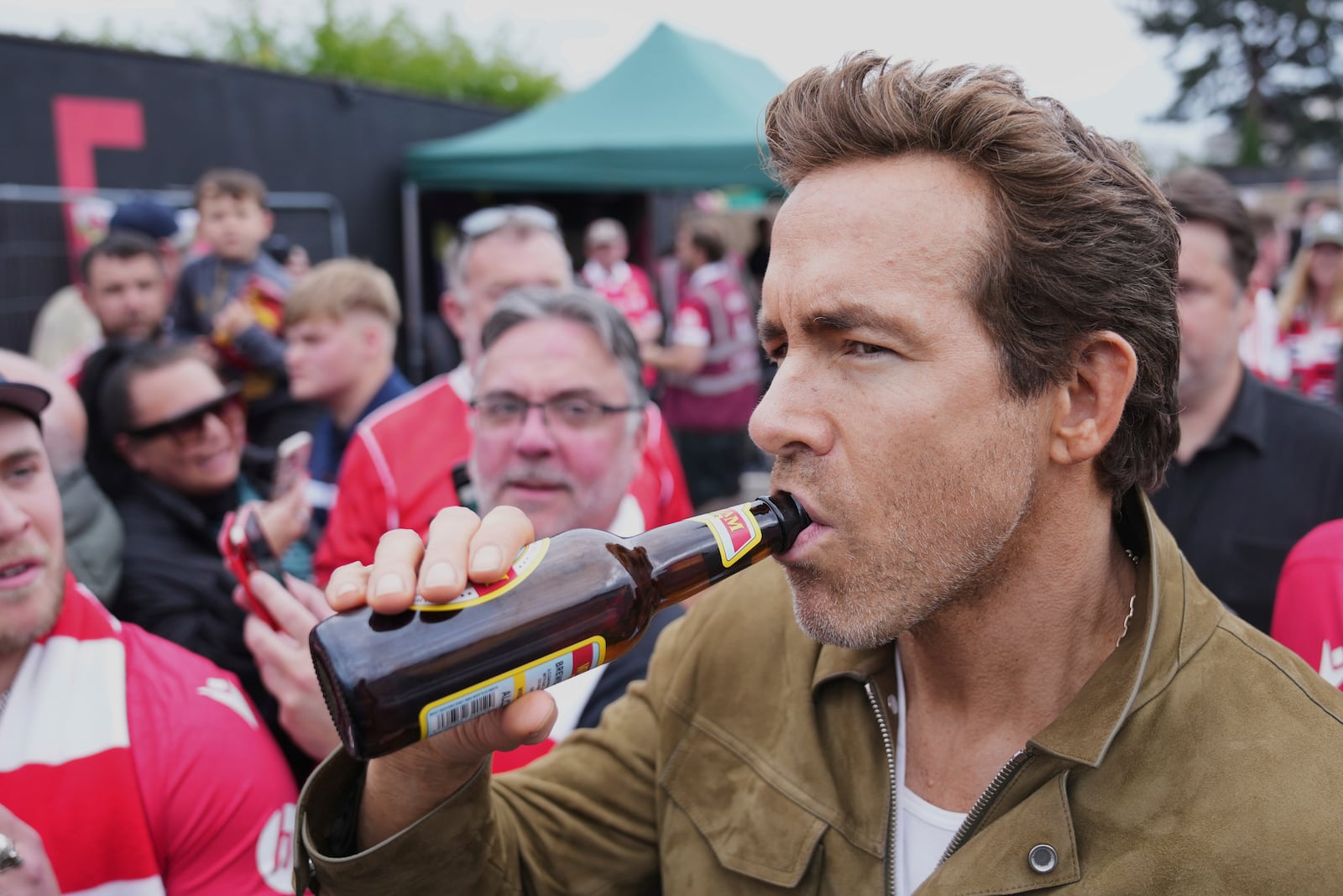Wrexham co-owner Ryan Reynolds sips beer prior to the English League One soccer match between Wrexham and Charlton Athletic at the Racecourse ground in Wrexham, Wales, Saturday, April 26, 2025. (AP Photo/Jon Super)