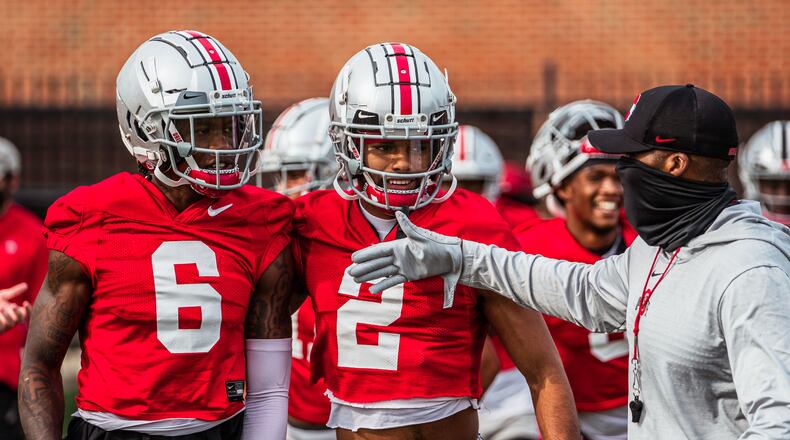 Ohio State coach Brian Hartline talks to Jameson Williams (6) and Chris Olave (2)