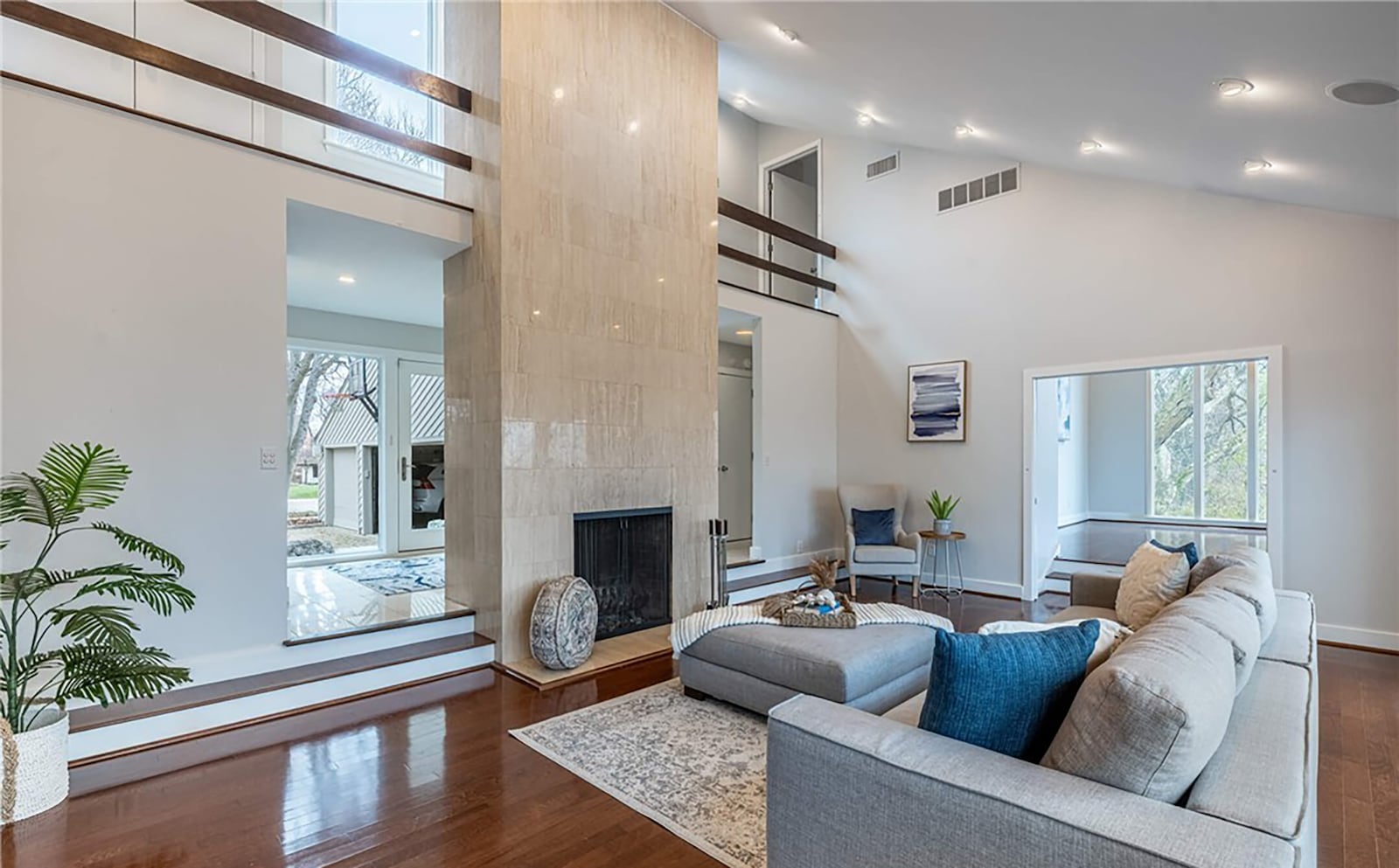 The two story sunken family room has a fireplace, wood floors, recessed lighting and exterior doors opening to the back deck. CONTRIBUTED