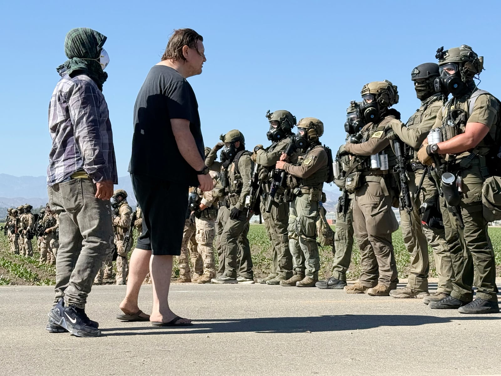 FILE - Demonstrators confront federal agents blocking a road during an immigration raid in Camarillo, Calif. (AP Photo/Michael Owen Baker, File)