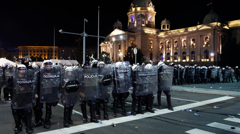 Serbian riot police separate rival crowds of opponents and loyalists of autocratic President Aleksandar Vucic, a day after tens of thousands of people joined a huge rally in the northern city of Novi Sad marking the first anniversary of a train station disaster there that killed 16 people, in Belgrade, Serbia, Sunday, Nov. 2, 2025. (AP Photo/Marko Drobnjakovic)
