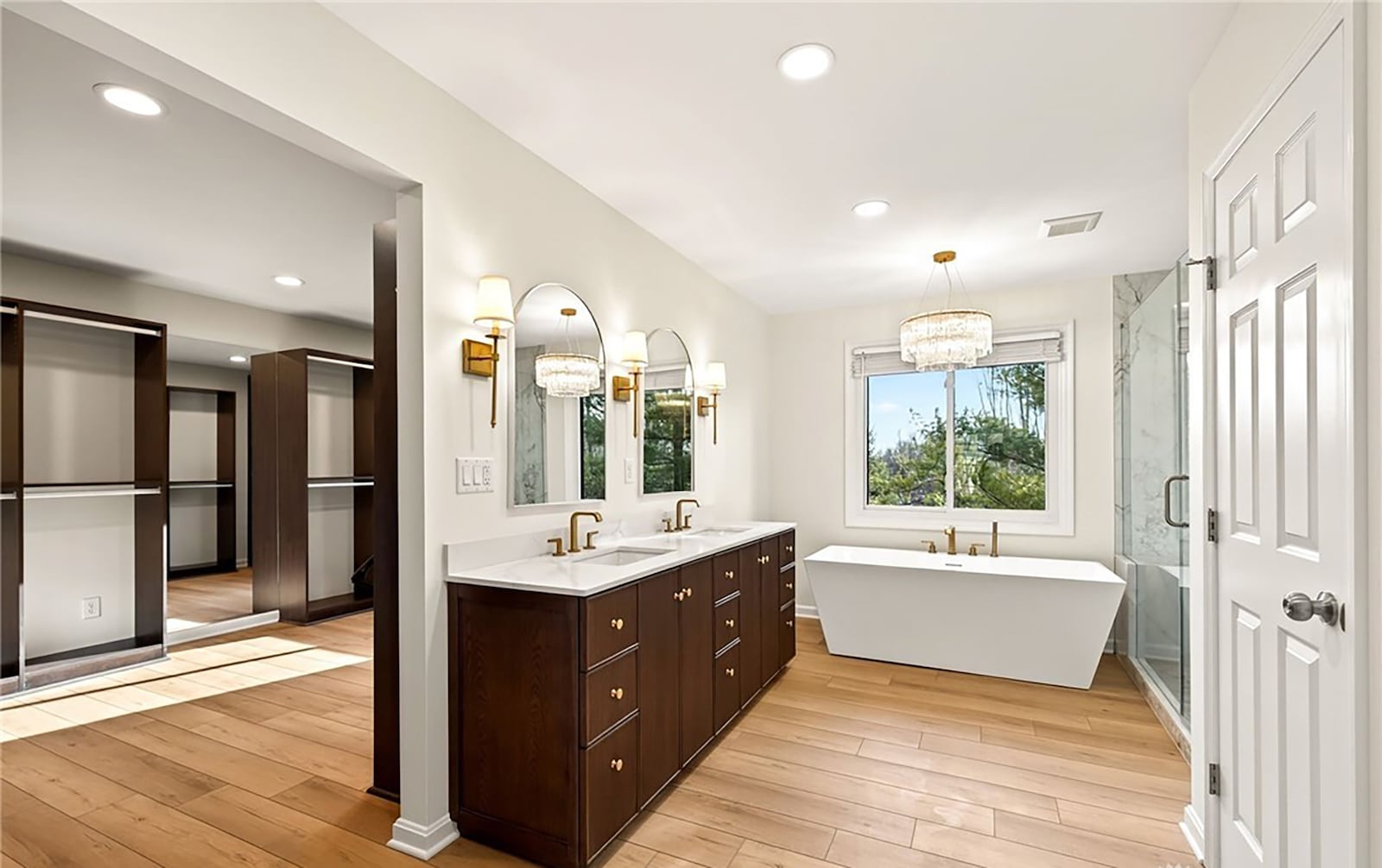 The primary bathroom has hardwood flooring, a double vanity and walk in shower and freestanding bathtub. The oversized walk in closet has a custom organizing system. CONTRIBUTED
