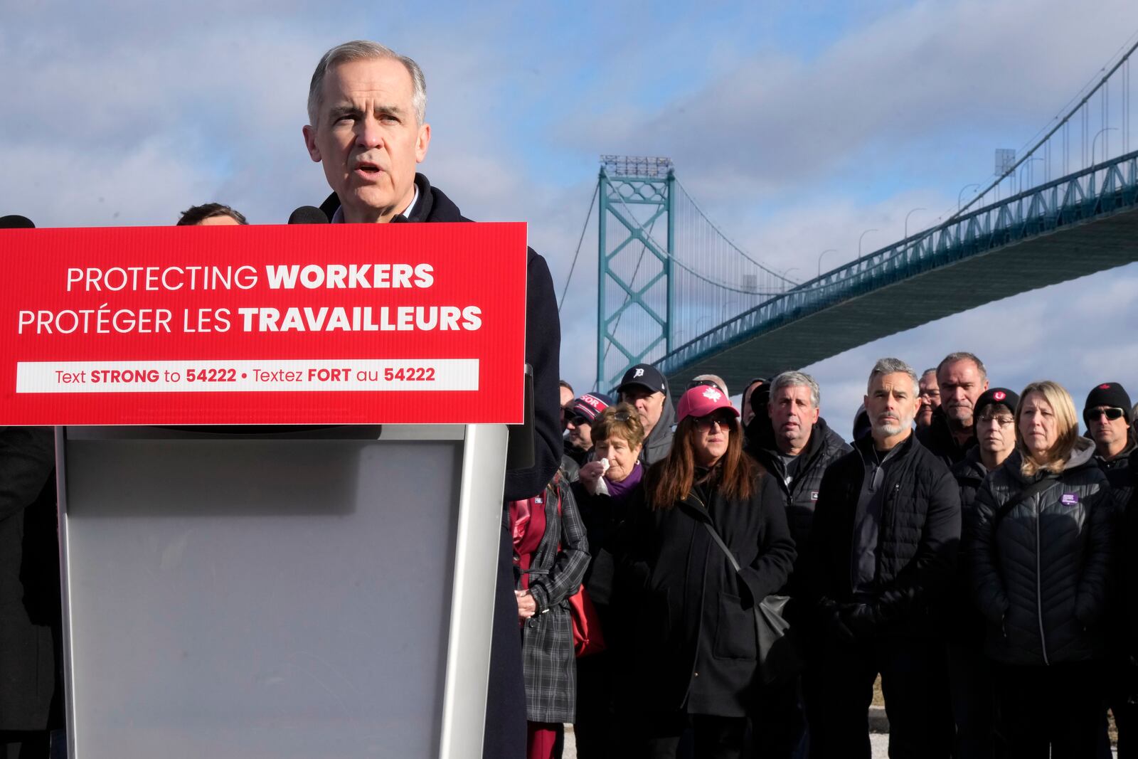FILE - Unifor auto workers stand behind Prime Minister Mark Carney as he speaks during a campaign stop in Windsor, Ont., March 26, 2025, near the Ambassador Bridge that connects Canada with the United States. (Frank Gunn /The Canadian Press via AP File)