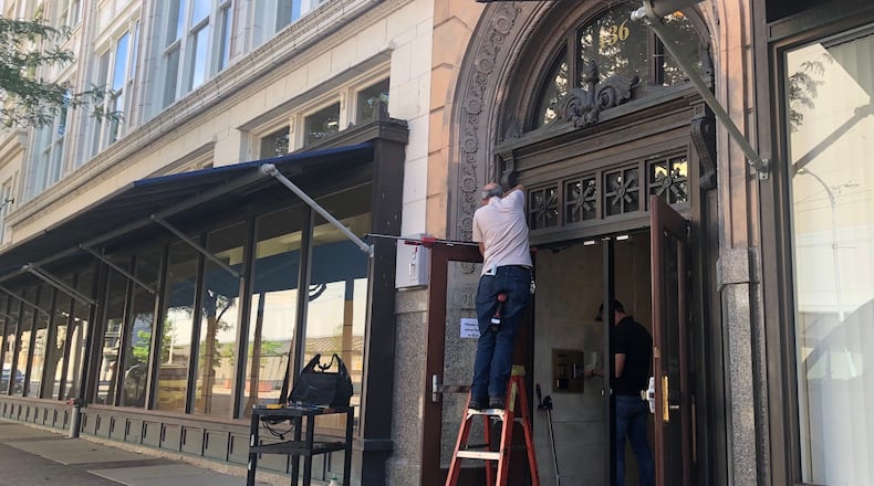 Contractors work on the front doors of the new Dayton Public Schools headquarters complex at 136 S. Ludlow St. on June 16, 2021. JEREMY P. KELLEY / STAFF