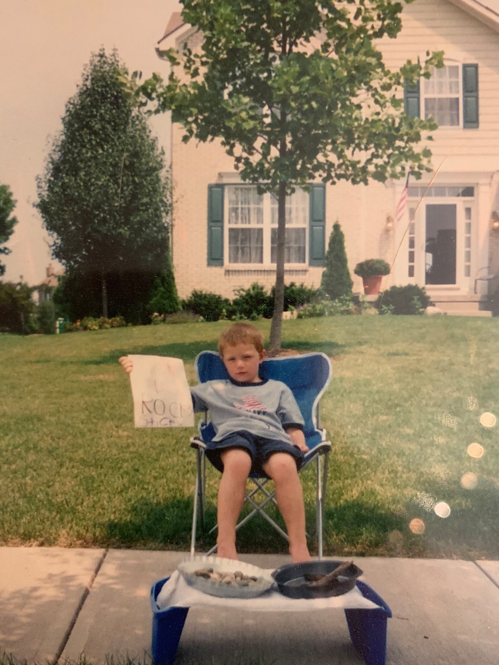 Nathan Minns as a child in front of his Centerville home. He quickly abandoned his lemonade stand and instead decided to try to sell interesting rocks and sticks he found in his back yard.