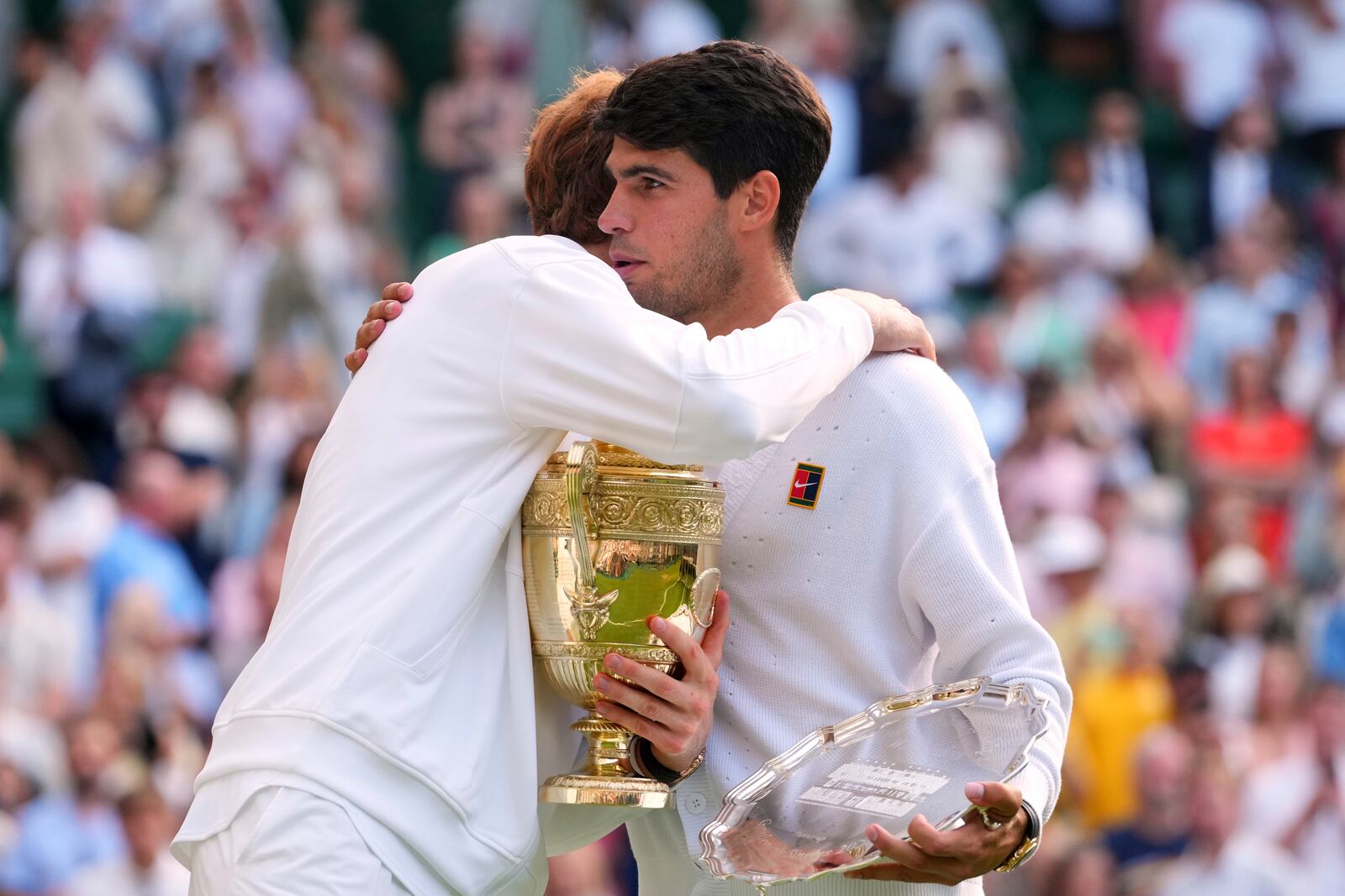 Jannik Sinner of Italy hugs Carlos Alcaraz of Spain after winning the men's singles final match at the Wimbledon Tennis Championships in London, Sunday, July 13, 2025.(AP Photo/Kirsty Wigglesworth)