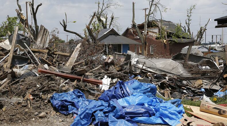 Mounds of tornado strewn debris are piled behind houses and apartments on Troy Street and Kelly Avenue in Old North Dayton. TY GREENLEES / STAFF