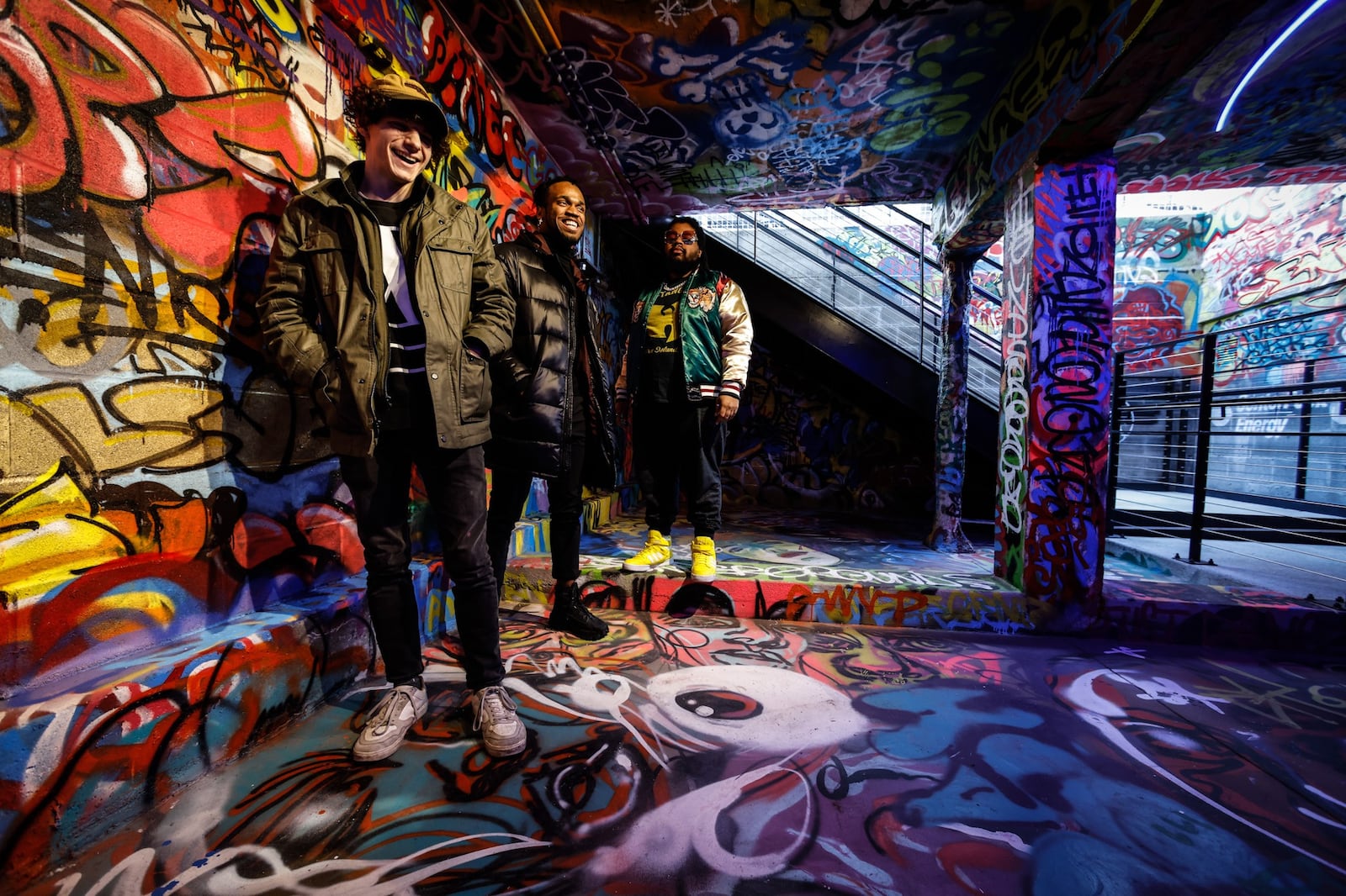 Artist from left, Nathan Roberts, Benjamin Baugham and Solomon Dickerson created a graffiti installation at the entrance to the tank inspired by Centerpoint Energy at the Dayton Arcade. JIM NOELKER/STAFF