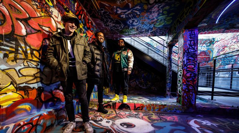 Artist from left, Nathan Roberts, Benjamin Baugham and Solomon Dickerson created a graffiti installation at the entrance to the tank inspired by Centerpoint Energy at the Dayton Arcade. JIM NOELKER/STAFF