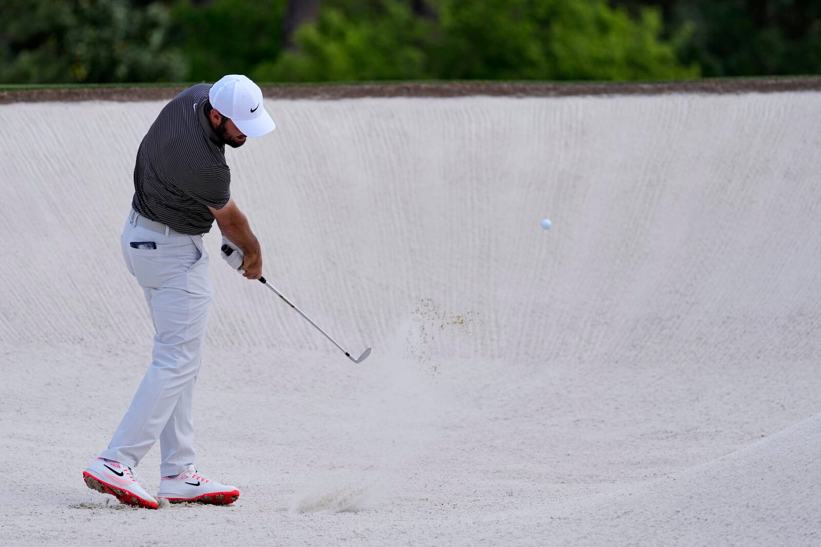 Scottie Scheffler hits from the bunker on the second hole during the third round at the Masters golf tournament, Saturday, April 12, 2025, in Augusta, Ga. (AP Photo/Ashley Landis)