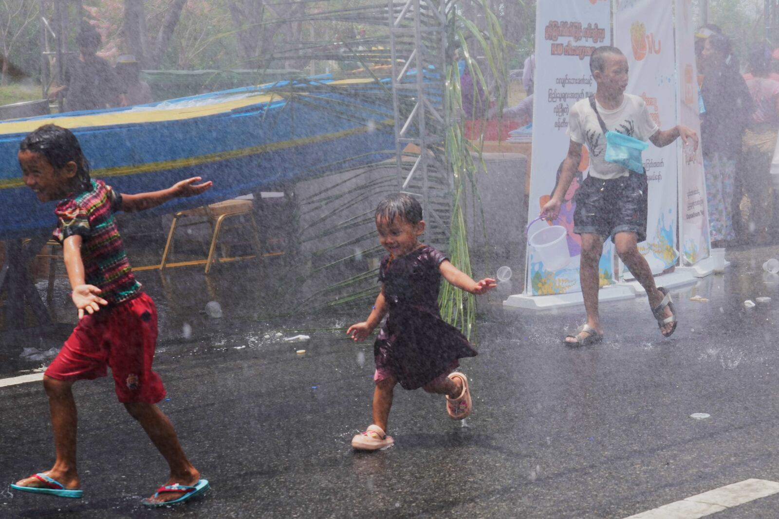 People take part in the first day of annual water festival also known as "Thingyan," in Naypyitaw, Myanmar, Sunday, April 13, 2025. (AP Photo/Aung Shine Oo)