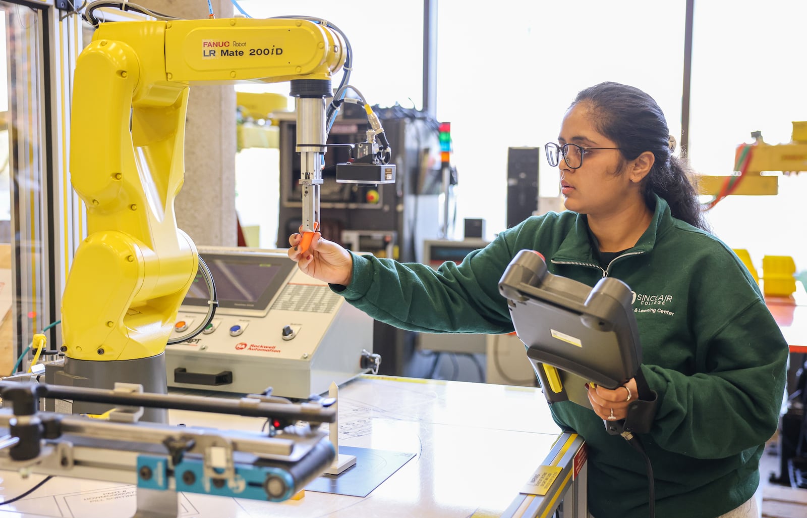 Neha Jadhav works on a program with a FANUC training robot in a robotics lab at Sinclair Community College on Monday, Nov. 24. BRYANT BILLING/STAFF