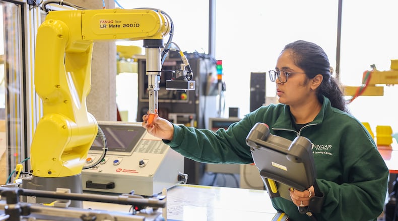 Neha Jadhav works on a program with a FANUC training robot in a robotics lab at Sinclair Community College on Monday, Nov. 24. BRYANT BILLING/STAFF