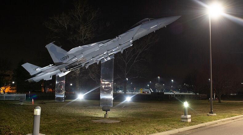 The two fighter aircraft on static display next to Gate 12A are lit up the night of March 16 at Wright-Patterson Air Force Base. U.S. AIR FORCE PHOTO/WESLEY FARNSWORTH