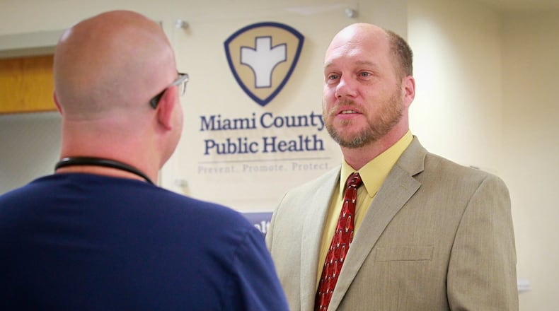 Dennis Propes, right, talks to Dr. Daniel Dilworth in the Miami County Health Department in Troy in this file photo. Propes, the county health commissioner, wants schools to do more to ensure people are wearing masks and practicing social distancing at school and sporting events. FILE