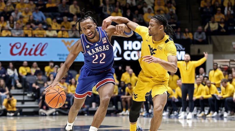 Kansas guard Darryn Peterson (22) is defended by West Virginia guard Jasper Floyd (1) during the second half of an NCAA college basketball game Saturday, Jan. 10, 2026, in Morgantown, W.Va. (AP Photo/Kathleen Batten)
