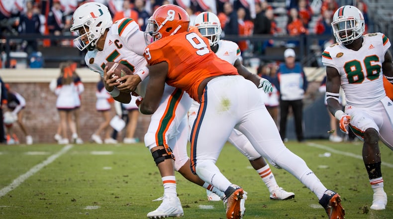 CHARLOTTESVILLE, VA - NOVEMBER 12: Brad Kaaya #15 of the Miami Hurricanes is sacked by Andrew Brown #9 of the Virginia Cavaliers during a game at Scott Stadium on November 12, 2016 in Charlottesville, Virginia. (Photo by Chet Strange/Getty Images)