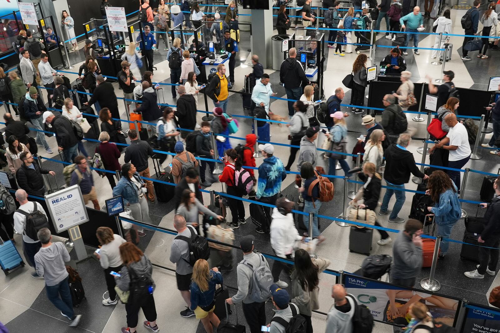 Dozens of travelers wait to go through security check point at O'Hare International Airport in Chicago, Friday, May 23, 2025. (AP Photo/Nam Y. Huh)