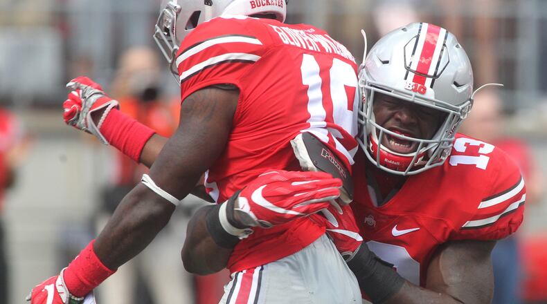 Ohio State’s Eric Glover-Williams, left, and Rashod Berry celebrate the first tackle of the season against Bowling Green on Saturday, Sept. 3, 2016, at Ohio Stadium in Columbus. David Jablonski/Staff
