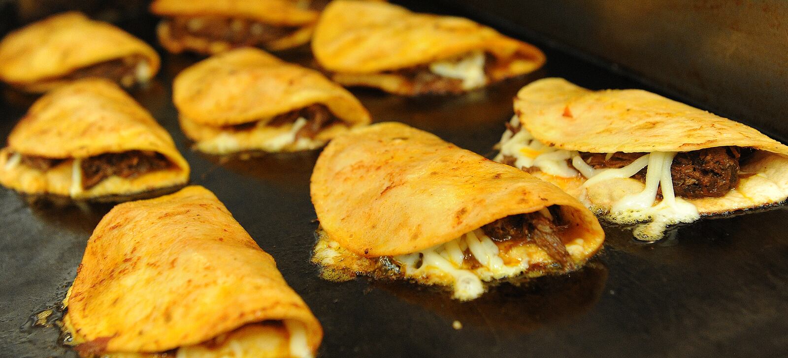 Taco Street Co. Birria Tacos cooking on the grill. MARSHALL GORBY\STAFF