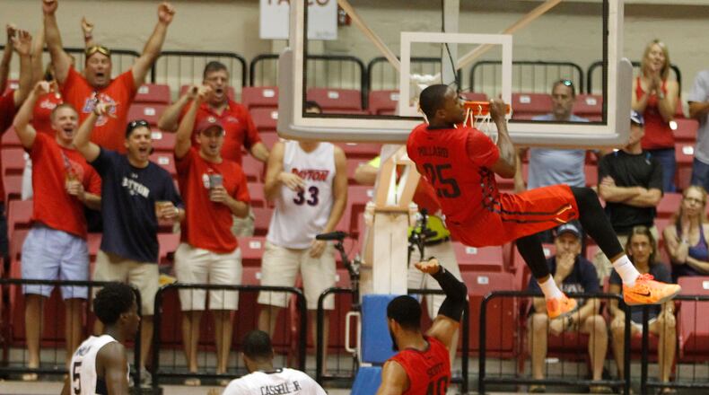 Dayton forward Kendall Pollard dunks and pull himself up on the rim against Connecticut in the semifinals of the Puerto Rico Tip-Off on Friday, Nov. 21, 2014, at Coliseo Roberto Clemente in San Juan, P.R. Pollard was called for a technical foul. David Jablonski/Staff