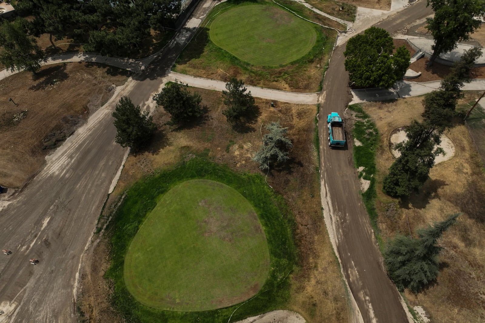 A dump truck exits a temporary recycling facility set up on a golf course in Altadena, Calif., Wednesday, June 4, 2025, after unloading debris removed from wildfires. (AP Photo/Jae C. Hong)