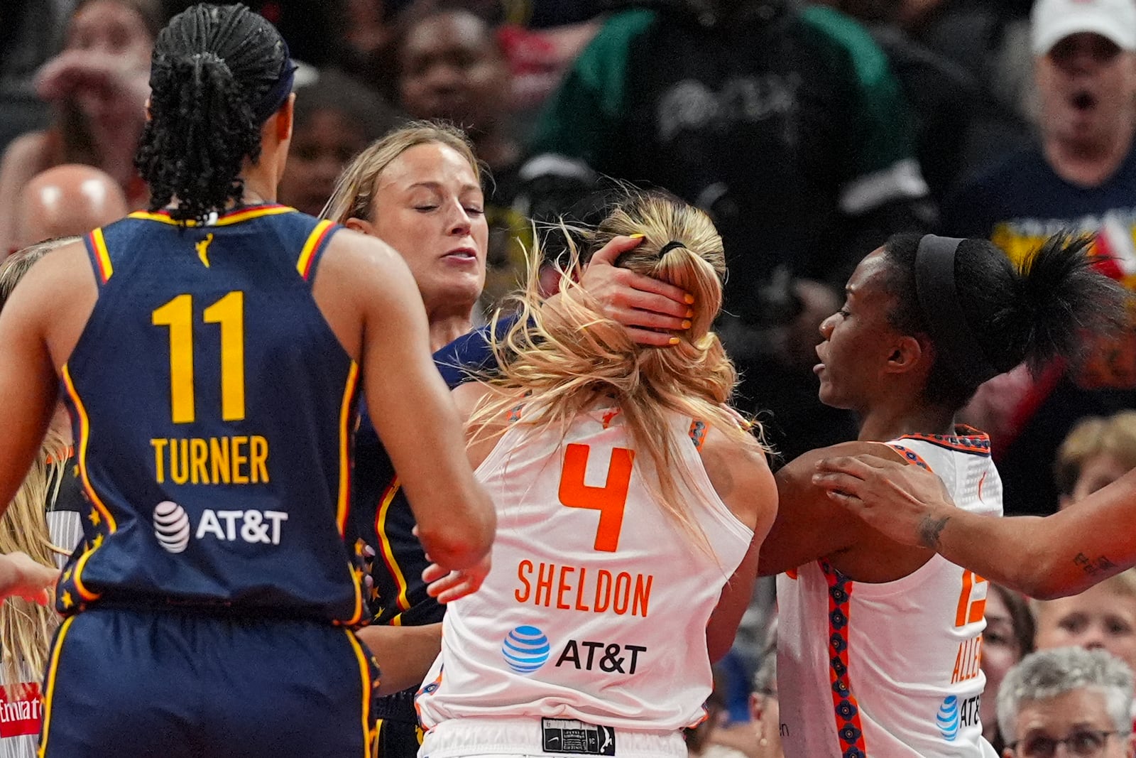 Indiana Fever guard Sophie Cunningham (8) and Connecticut Sun guard Jacy Sheldon (4) scuffle in the second half of a WNBA basketball game in Indianapolis, Tuesday, June 17, 2025. (AP Photo/Michael Conroy)