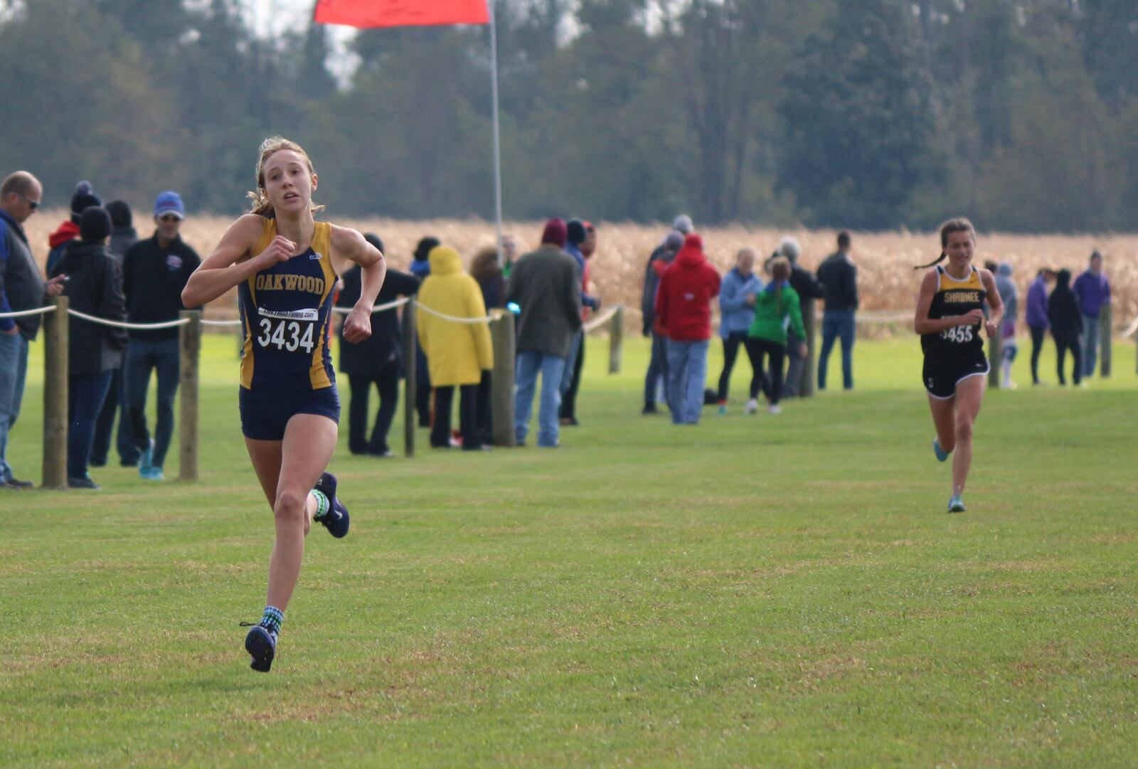 Oakwood freshman Grace Hartman sprints to the Division II girls district championship ahead of Springfield Shawnee freshman Audrey DeSantis at Cedarville University on Saturday. Contributed / Greg Billing