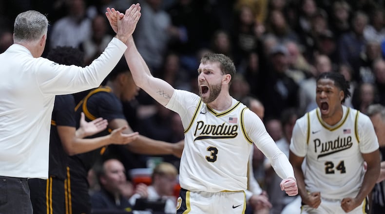 Purdue guard Braden Smith (3) high-fives head coach Matt Painter, left, after forcing a turnover against Iowa during the second half of an NCAA college basketball game in West Lafayette, Ind., Wednesday, Jan. 14, 2026. (AP Photo/Michael Conroy)