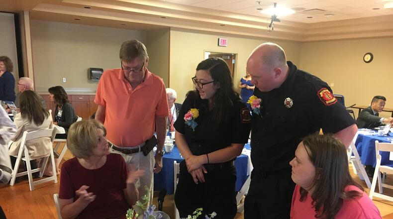 Two Lebanon paramedics, Emily Reynolds and Jesse McPherson, greet Dale and Marjorie Bottorff and their son, Nicholas, Wednesday night before the Atrium Medical Center Survivors Banquet. RICK McCRABB/STAFF