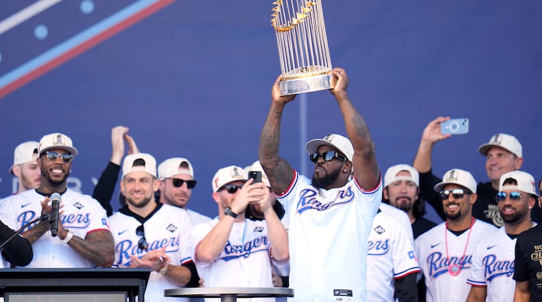 FILE - Texas Rangers' Adolis Garcia, surrounded by teammates and staff, holds up the Commissioner's Trophy during a World Series baseball championship celebration, Friday, Nov. 3, 2023, in Arlington, Texas. (AP Photo/Julio Cortez, File)