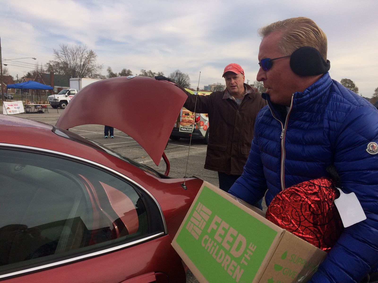 Fazoli’s CEO Carl Howard loads boxes into a local family’s vehicle. About 400 families in need received donations Wednesday. STAFF PHOTO / HOLLY SHIVELY