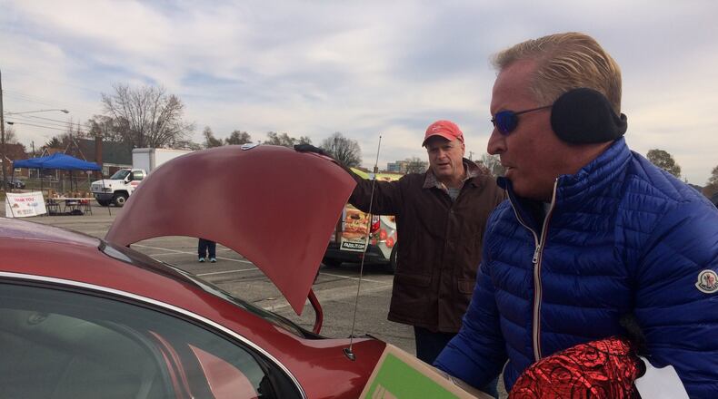 Fazoli’s CEO Carl Howard loads boxes into a local family’s vehicle. About 400 families in need received donations Wednesday. STAFF PHOTO / HOLLY SHIVELY