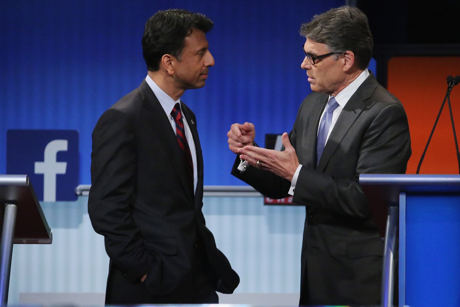 CLEVELAND, OH - AUGUST 06: Republican presidential candidates Louisiana Gov. Bobby Jindal (L) and Rick Perry visit during a commercial break during a presidential pre-debate forum hosted by FOX News and Facebook at the Quicken Loans Arena August 6, 2015 in Cleveland, Ohio. Jindal, Perry and five other GOP candidates were selected to participate in the forum based on their rank in an average of the five most recent national political polls. (Photo by Chip Somodevilla/Getty Images)