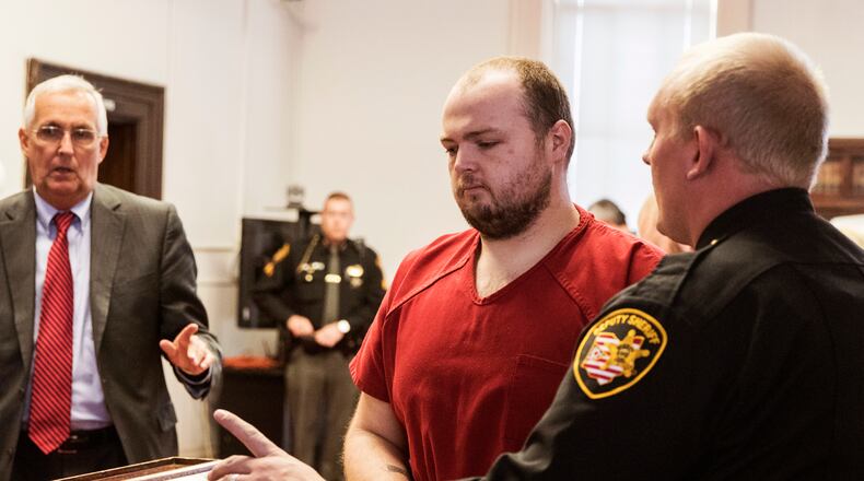 FILE—In this file photo from Nov. 28, 2018, George Wagner IV, center, is escorted out of the courtroom after his arraignment at the Pike County Courthouse, in Waverly, Ohio. Wagner, his parents and brother were charged in the 2016 shootings of eight members of the Rhoden family. Ohio Judge Randy Deering on Wednesday Dec. 22, 2021, denied a request by lawyers for Wagner to dismiss his aggravated murder charges, thereby keeping the death penalty on the table for the man accused in the slayings of eight people from a single family. The lawyers said Wagner's brother, who pleaded guilty this year in the shootings, admitted to killing five of the victims and that George Wagner IV didn't kill anyone.(Robert McGraw//The Chillicothe Gazette via AP, Pool, File)