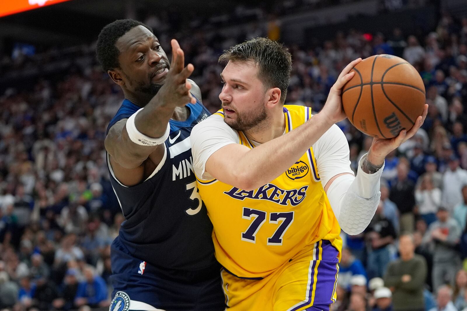 Los Angeles Lakers guard Luka Doncic (77) looks to pass as Minnesota Timberwolves forward Julius Randle (30) defends during the second half of Game 3 of an NBA basketball first-round playoff series, Friday, April 25, 2025, in Minneapolis. (AP Photo/Abbie Parr)