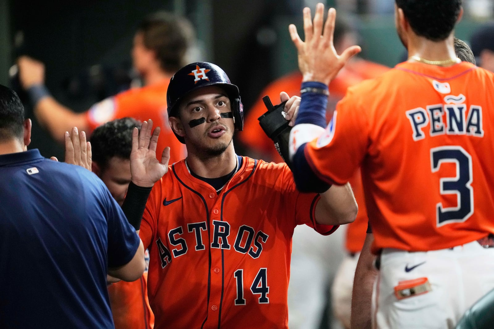 Houston Astros' Mauricio Dubon (14) celebrates in the dugout after scoring off of a double hit by Isaac Paredes during the fifth inning of a baseball game against the Cincinnati Reds in Houston, Friday, May 9, 2025. (AP Photo/Ashley Landis)
