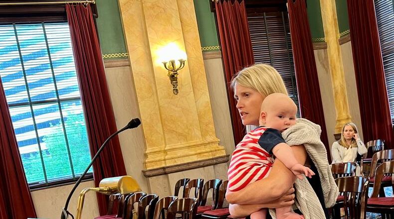 Erin Merryn testified Tuesday before the Ohio Senate Primary and Secondary Education Committee. She is holding her three-month-old son, Jack. On the podium is a pink childhood diary where she wrote about being sexually abused, because she was afraid to tell any safe adults. Laura Hancock/cleveland.com