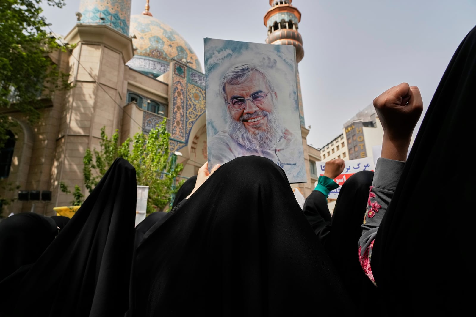 Iranian protesters chant slogans as one of them holds up a poster of Lebanon's Hezbollah former leader Hassan Nasrallah, who was killed by Israel, during an anti-Israeli demonstration at the Felestin (Palestine) Sq. in Tehran, Iran, Wednesday, April 9, 2025. (AP Photo/Vahid Salemi)