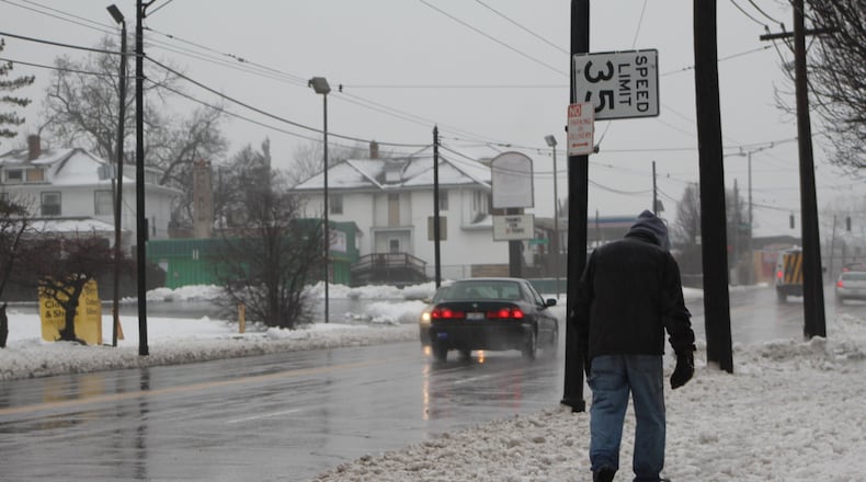 A man walks along North Main as cars drive past traveling well above the posted speed limit of 35 mph. CORNELIUS FROLIK / STAFF