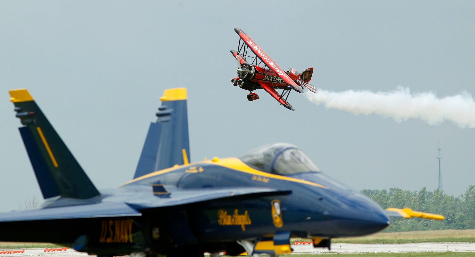 John Klatt's Scramin' Sasquatch is a 1929 Waco taperwing biplane equipped with a jet engine at Vectren Dayton Air Show.  Klatt appears to be flying over Blue Angel #3 as he approaches show center on Friday, June 22, 2018.  TY GREENLEES / STAFF