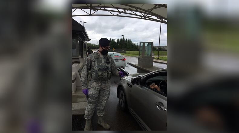 Senior Airman Aaron Marketich, 88th Security Forces Squadron, demonstrates the mask and gloves he and fellow defenders are utilizing during the COVID-19 situation on May 18 at Wright-Patterson Air Force Base’s Gate 12A. In the background is Senior Airmen Joshua Gravel, entry controller. (Skywrighter photo/Amy Rollins)