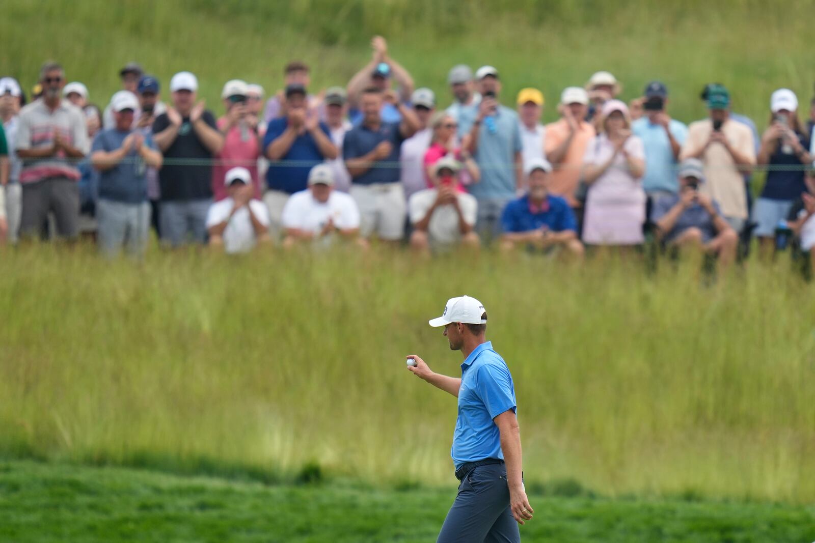Victor Perez, of France, acknowledges fans as he walks up to the seventh tee after making a hole in one on the sixth hole during the second round of the U.S. Open golf tournament at Oakmont Country Club Friday, June 13, 2025, in Oakmont, Pa. (AP Photo/Seth Wenig)