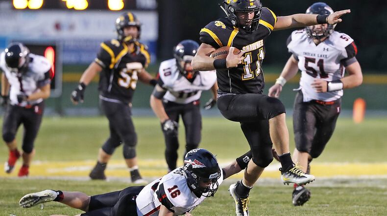 Shawnee’s Jack McCrory slips a tackle by Indian Lake’s Clay Jacobs as he carries the ball during Friday’s game. Bill Lackey/Staff
