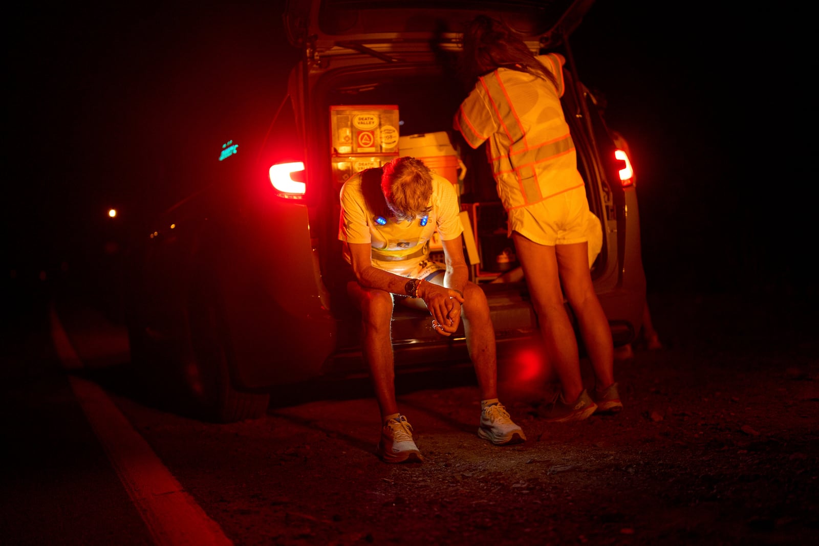 Danny Westergaard rests beside Jennifer Drain, his cousin and crew lead, during the second night of the Badwater 135 Ultramarathon, Tuesday, July 8, 2025, in Death Valley National Park, Calif. (AP Photo/John Locher)