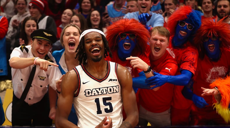 Dayton's DaRon Holmes II celebrates with fans in the Red Scare student section after a victory against Fordham on Saturday, Feb. 17, 2024, at UD Arena. David Jablonski/Staff