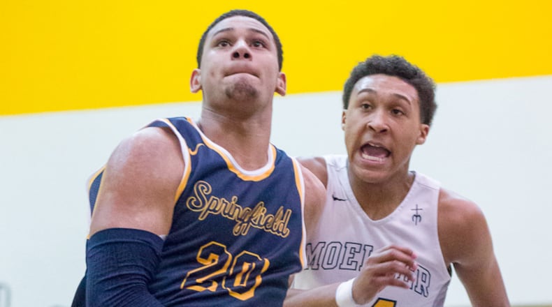 Springfield junior forward Leonard Taylor shoots with pressure from Moeller’s Jeremiah Davenport during a nonconference game on Saturday night. Contibuted Photo by Bryant Billing